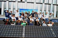 L’equip d’estudiants i estudiantes de la UPC i les plaques que formen part de la la primera instal·lació fotovoltaica al terrat de l’edifici TR11.