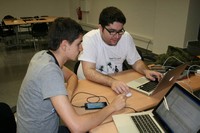 El titulat Pau Corbella i el doctorand Alberto Irurueta davant els ordinadors durant la realització del  'HackForGood' a Barcelona