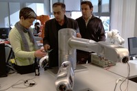 Els investigadors Josep Amat (al centre), Alícia Casals i Manel Frigola davant els braços robòtics de Bitrack.