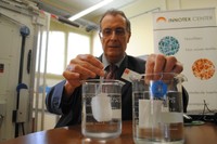 Feliu Marsal sostiene, en el interior del recipiente de la derecha, el tampón Cohitech, con una forma regular en comparación al tampón de la izquierda después de ser sumergidos ambos en agua.